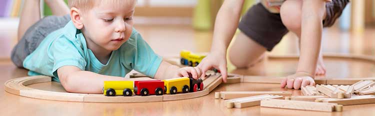jungs-spielen-mit-holzeisenbahn